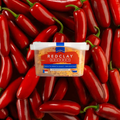 Red Clay Gourmet's South Meets East ~ Sriracha flavored Pimiento Cheese container surrounded by red peppers